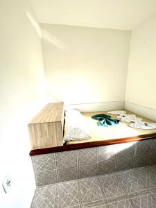 a small room with a bed with a box on it at Pousada Realce in Vera Cruz de Itaparica