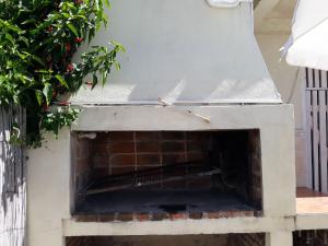 Suíte في بونتا دل إستي: مدفأة حجرية فوقها ساعة