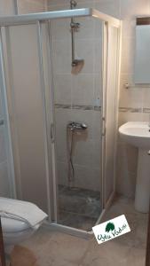 a shower with a glass door in a bathroom at Uyku Vadisi Hotel in Ağaçlıhüyük