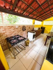 cocina con fogones en el suelo de baldosa en Sítio Adonai Pousada & Eventos en Guarapari