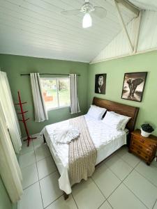 Un dormitorio con una cama grande y una ventana en Sítio Adonai Pousada & Eventos, en Guarapari