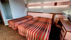 Postel nebo postele na pokoji v ubytování Hôtel Siatel Besançon Chateaufarine