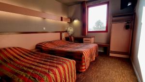 Postel nebo postele na pokoji v ubytování Hôtel Siatel Besançon Chateaufarine