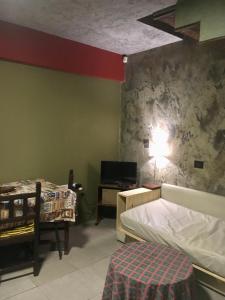 1 dormitorio con 1 cama y 1 mesa con lámpara en Arroyo en Alta Gracia
