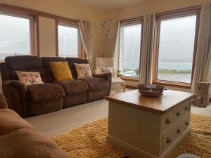 uma sala de estar com um sofá e uma mesa em Hector's Bothy flat em Kyle of Lochalsh