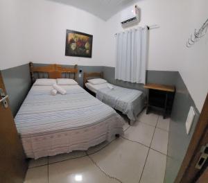 a bedroom with two beds and a table and a window at Casa Flor do Ipê Homes in Nobres