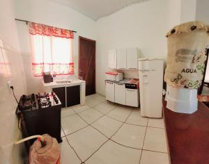 eine Küche mit einem Herd und einem Kühlschrank in der Unterkunft Casa Flor do Ipê Homes in Nobres