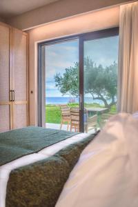 a bedroom with a bed and a view of the ocean at Panorama Hotel in Falasarna
