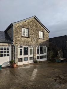 una casa de ladrillo con puertas blancas y entrada en 2 Stable Cottage, Llanbethery en Llancarfan