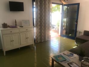 ein Wohnzimmer mit einem Sofa, einem TV und einem Tisch in der Unterkunft Vivienda Vacacional Delia Castillo a 100 metros de la playa in Caleta de Fuste