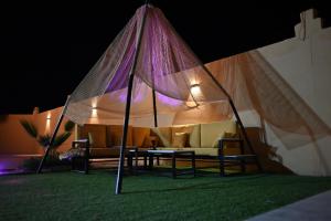 a tent with two chairs and a table under it at منتجع وإسطبل الهدوء in Riyadh