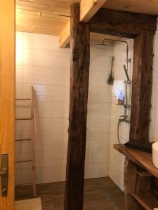 a bathroom with a shower with a wooden beam at Koliba 30svibnja in Perušić +39 photos