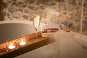 einen Tisch mit einem Glas Champagner und Kerzen in der Unterkunft La petite Reuleau - Gites champêtre le "FENIL" et la "FERMETTE et son sauna privatif" in Ciney
