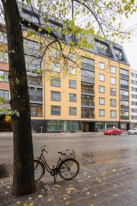 una bicicleta estacionada junto a un árbol al lado de un edificio en Sari’s luxury studio in the city center en Turku