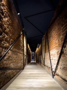 a long alley way with a brick wall at Hotel ICONICO JUJUY Centro in San Salvador de Jujuy