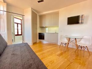 een woonkamer met een tafel en een keuken bij Porto.Leça - Studios and Apts (Apt H) in Leça da Palmeira