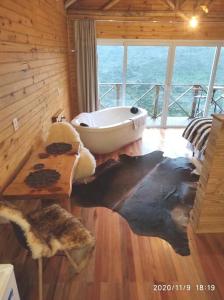 y baño con bañera en el suelo de madera. en @lacascatachales Chalé Curucaca, en Urubici