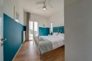 a bedroom with a large bed and blue walls at Knots apartments in Ágios Nikólaos