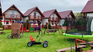 uma casa com um parque infantil com um triciclo no quintal em Domki wczasowe u Ewy em Chłopy