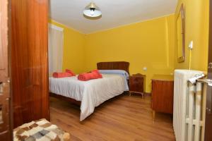Un dormitorio con una cama con almohadas rojas. en Astorga. León. Piscina. Casa Val de San Lorenzo., en Val de San Lorenzo 15 fotos más