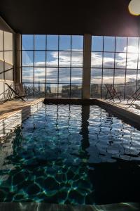 a swimming pool in a building with a view at Un petit bout du monde in Saint-Georges-en-Couzan
