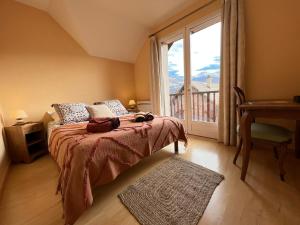 a bedroom with a bed and a large window at MAISON DES VIGNES in Embrun