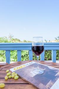 Pachaina的住宿－阿斯特拉奧旅館，坐在桌子上喝一杯葡萄酒
