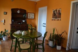 a dining room with a green table and chairs at Casa VELARDI in Viagrande