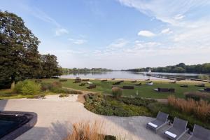 Aspria Hannover Maschsee Sport & Spa في هانوفر: اطلالة على حديقة بها كراسي وبحيرة