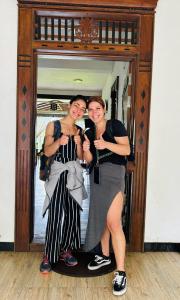 duas mulheres estão posando em frente a um espelho em Heritage villa polonnaruwa em Polonnaruwa