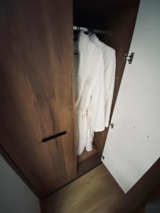 a closet with white clothes hanging in it at TALIA Apartament Tatarska 4 in Przemyśl