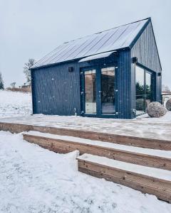 a blue building in the snow with snow at Ežerėja 