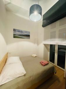 a bedroom with a bed and a lamp and a window at TALIA Apartament Tatarska 4 in Przemyśl