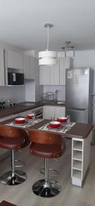una cocina con una mesa con placas rojas. en Bonito y Acogedor Dpto Av Pacífico 3100, La Serena en La Serena