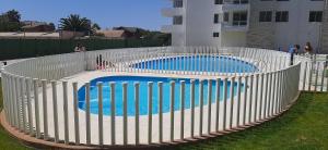 una valla blanca alrededor de una piscina en un patio en Bonito y Acogedor Dpto Av Pacífico 3100, La Serena, en La Serena