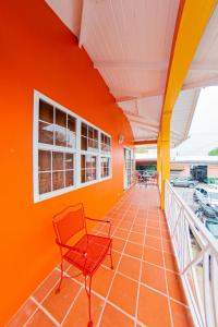 una silla roja en una habitación con una pared de color naranja en JR Apartments en Georgetown