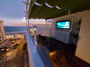a balcony with a flat screen tv on the side of a building at ÁTICO VICTORIA BEACH in Cádiz