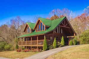 a large wooden house with a green roof at *Family friendly cabin near Dollywood! in Pigeon Forge