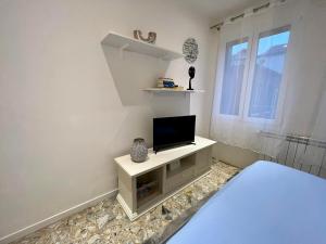 uma sala de estar com televisão numa parede branca em New Apartment Venice 1 em Veneza