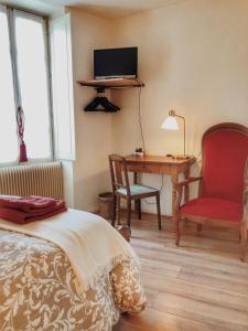 um quarto com uma cama, uma secretária e uma cadeira em Gîte Les Roches : maison de caractère pour 15 personnes em Saint-Romain