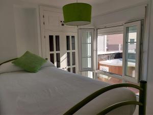 a bedroom with a bed and a large window at ÁTICO VICTORIA BEACH in Cádiz
