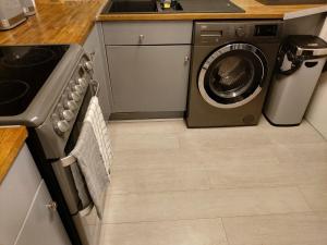 a kitchen with a stove and a washing machine at Heronsgate GH009 in Abbey Wood