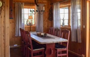 a wooden dining room with a table and chairs at 3 Bedroom Amazing Home In Nord-torpa in Nord Torpa