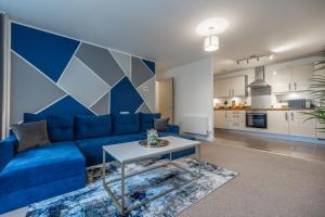 een woonkamer met een blauwe bank en een tafel bij Modern 2 bed in central MK, Free Parking, Smart TV Dakota By Valore Property Services in Milton Keynes