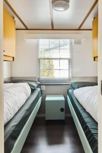 Cette chambre comprend 2 lits et une table. dans l'établissement 4 persons chalet Valkenbosch situated in the forested area, à Oisterwijk