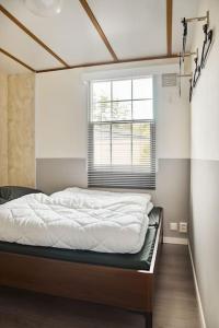 Ce lit se trouve dans un dortoir doté d'une fenêtre. dans l'établissement 4 persons chalet Valkenbosch situated in the forested area, à Oisterwijk