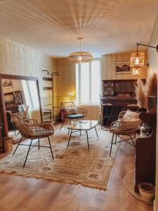 uma sala de estar com cadeiras e uma mesa em Gîte Les Roches : maison de caractère pour 15 personnes em Saint-Romain