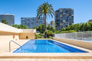 una piscina con edifici in città sullo sfondo di Torre Levante 24-B Levante Beach a Benidorm