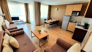 een woonkamer met een bank en een tafel bij Obzor Beach Resort Apartment G-109 in Obzor