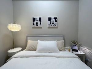 1 dormitorio con 1 cama con 3 cuadros en la pared en Euphoria Suite: Dream Room @Uptown Parksuites 2, en Manila